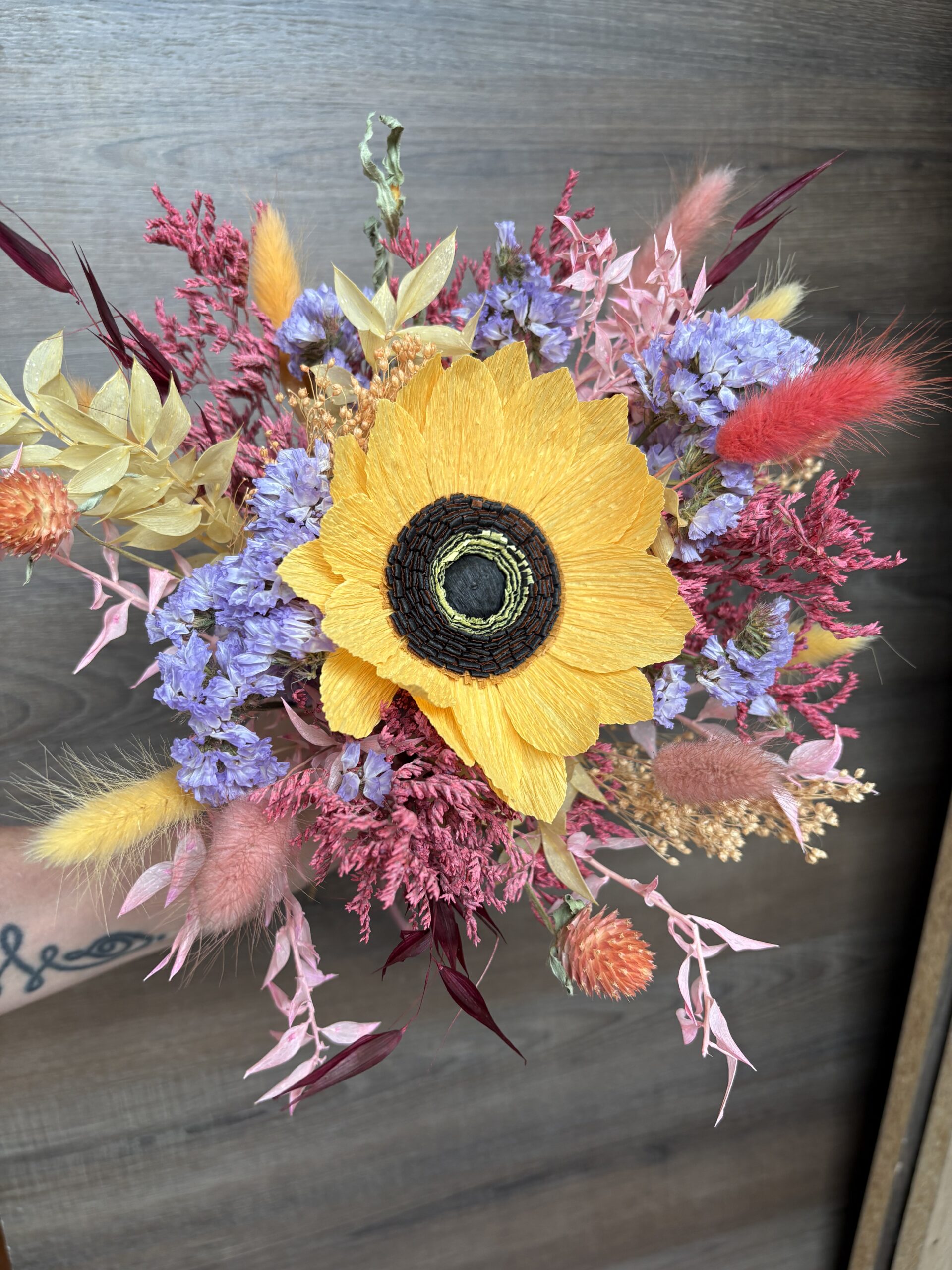 Un bouquet de fleurs séchées avec un tournesol éternel en papier
